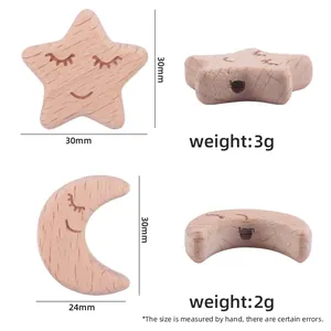 Macro view of beech wood star and moon teether beads with smiling faces and drill holes