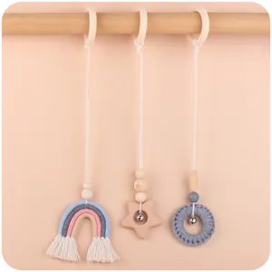 Détail lot de 3 jouets en bois pour portique bébé avec arc-en-ciel, étoile et hochet