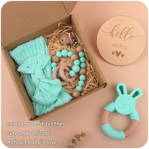 Baby gift set with mint green bunny teether, pacifier clip and bow headband in a kraft box