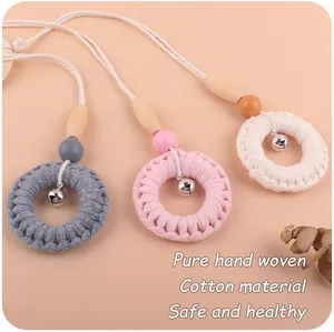 Détail de trois pendentifs arc-en-ciel faits main avec perles en hêtre et cloches en métal