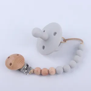 Baby pacifier set with gray silicone dummy and wooden beaded clip chain on white background