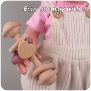 Detail van houten babyrambelaar met paarse siliconen kralen vastgehouden door een pop