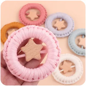 Detail of handmade star-shaped cotton woven baby teether ring in pastel macaron colors