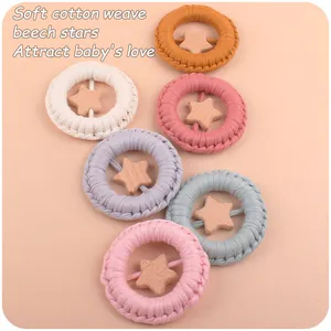Detail of six colorful handmade cotton woven baby teething rings with beech wood stars