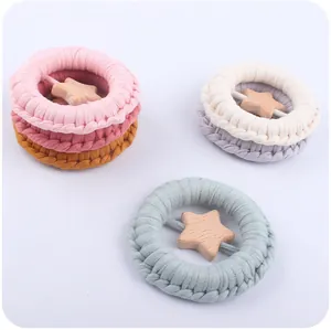 Detail of star-shaped wooden charms on colorful knitted hair ties for infants