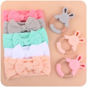 Baby teething set with silicone rabbit rings and colorful knit bow headbands in soft pastels