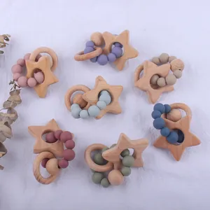 Flat lay of star-shaped beech wood and silicone teething rings in seven Morandi colors