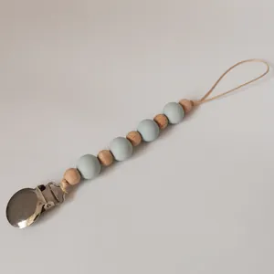Detail of baby pacifier clip with wood beads, blue silicone beads and metal clasp