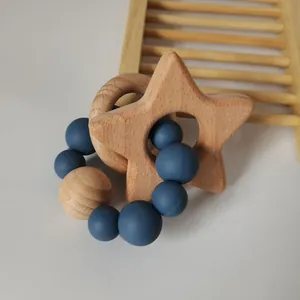 Detail of baby teething ring with star beech wood and navy blue silicone beads