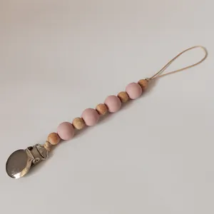 Close-up of pink silicone and natural wooden beads on a baby pacifier clip chain
