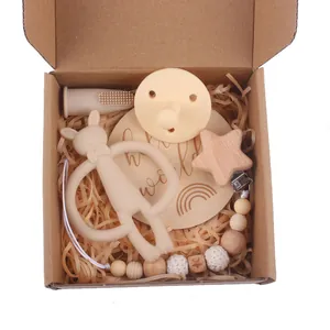 Close-up of baby gift set including silicone bunny teether and wooden pacifier clip in a box
