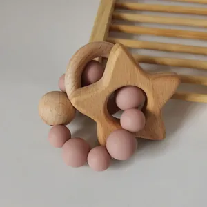 Macro shot of natural beech wood star and silicone beads teething ring for infants