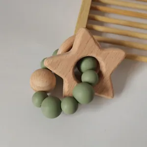 Detail of star-shaped beech wood teether with green silicone beads for infants