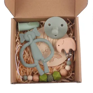 Close-up of baby gift set with silicone elephant teether and wooden pacifier clip
