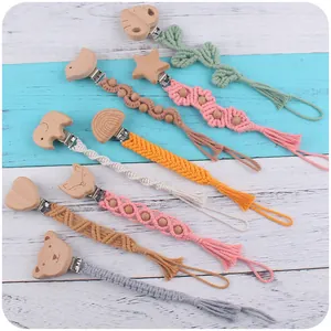 Détail d'attaches-tétines en macramé fait main avec divers clips en bois de hêtre sculpté