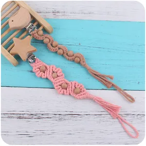 Détail d'attaches-tétines en macramé avec perles de hêtre et breloques d'animaux