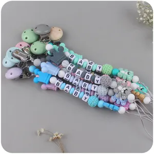 Macro detail of silicone pacifier clips with wood beads and bear shaped teething charms