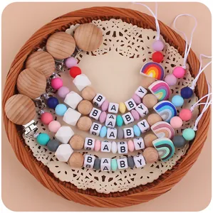 Detail van de siliconen fopspeenketting met regenboog, houten kralen en BABY-letters