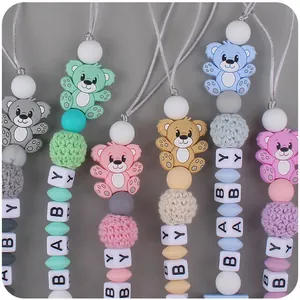 Detail of colorful silicone baby pacifier chains with bear charms and BABY letter beads