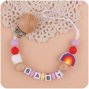Detail van siliconen regenboog speenkoord met baby kralen en houten clip sluiting