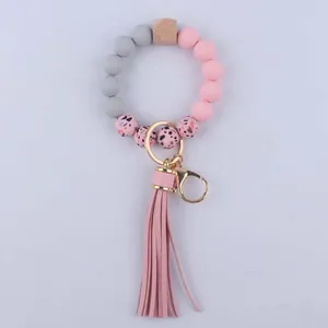 Detail of pink silicone beads, wooden hexagon bead, and faux leather tassel keychain