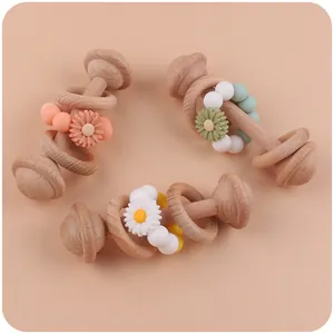 Detailed overhead view of wooden baby rattles with silicone beads and daisy accents
