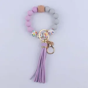 Detail of beaded silicone wristlet keychain with purple leather tassel and metal clasp