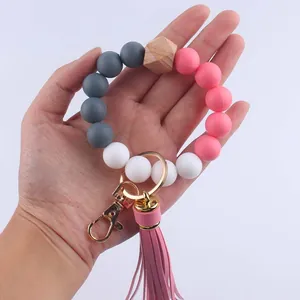 Silikon-Perlen-Armband Schlüsselanhänger mit rosa Quaste und Holzperle in der Hand