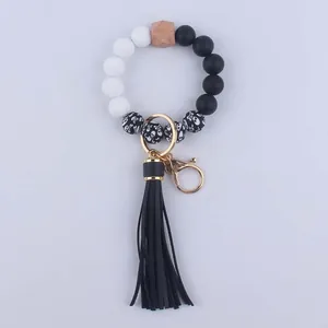 Close-up of beaded keychain with black leather tassel, silicone skulls, and golden hardware