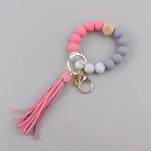 Detail van de siliconen kralenarmband in roze en grijs met kwastje en gouden metalen sluiting