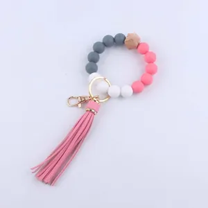 Detailansicht Silikon-Perlenarmband mit Holzperle und rosa Lederquaste Anhänger