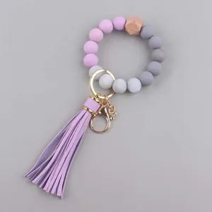 Detail van kralenarmband sleutelhanger met lila siliconen kralen en leren kwastje