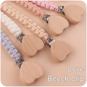 Detail of beech wood heart clip and handmade woven pacifier chain in macaron colors