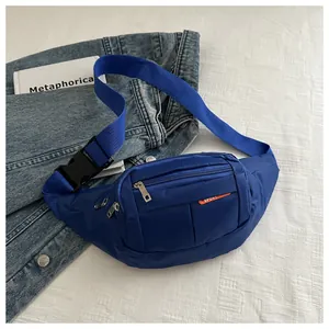 Detail of blue nylon waist bag with multiple zippers and orange Sport label on denim jacket
