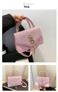 Vue détaillée du sac à main rose à paillettes avec boucle S dorée et pompon à franges