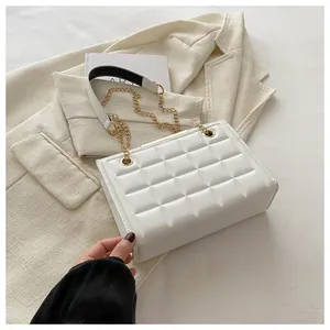 Primer plano detallado del bolso bandolera blanco acolchado con cadena dorada en blazer