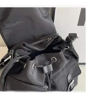 Detail of the drawstring opening with metal eyelets on a black canvas leisure bag