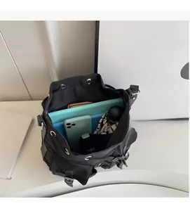 Top view of spacious black canvas bucket bag interior with daily essentials and tablet