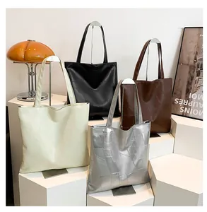 Four colors of geometric pattern tote bags displayed on white minimalist stands