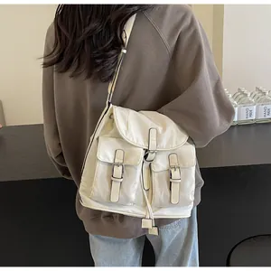 Detailed view of the multi-pocket cream canvas backpack with retro metal buckles and straps