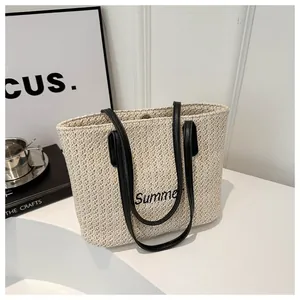 Détail du sac cabas en paille tissée avec broderie Summer noire et anse en cuir
