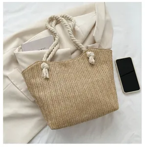 Detailed herringbone weave pattern on straw tote bag with sturdy cotton rope handles
