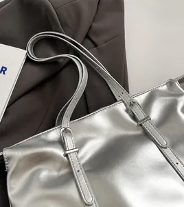 Detail of adjustable silver metallic strap with needle buckle on a fashion tote bag