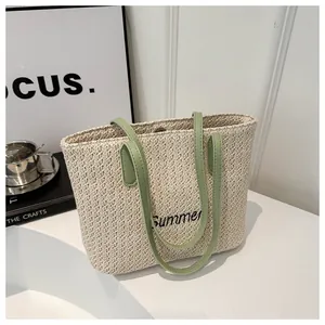 Gros plan du sac cabas tissé avec broderie Summer et anses en cuir vert clair