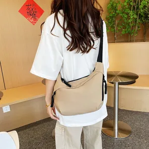 Detail view of khaki large capacity dumpling crossbody bag with black woven straps