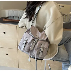 Detail of light purple canvas bag showing exterior pockets and buckle straps close-up