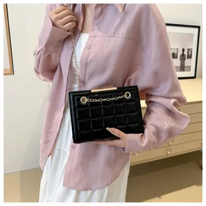 Bolso bandolera acolchado negro con cadena dorada lucido por modelo para estilo moda