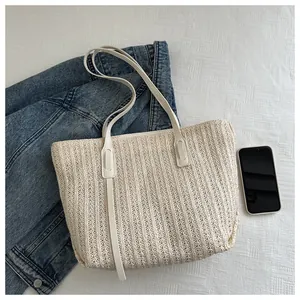 Close-up of cream woven tote bag texture with slim handles and vertical stripe pattern