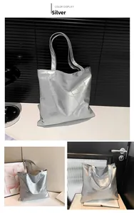 Detailed view of silver metallic tote bag with geometric textured panels in modern setting