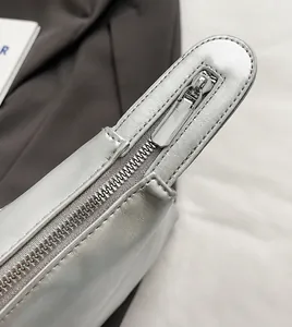 Detail of high-quality smooth metal zipper and silver leather puller on travel tote bag